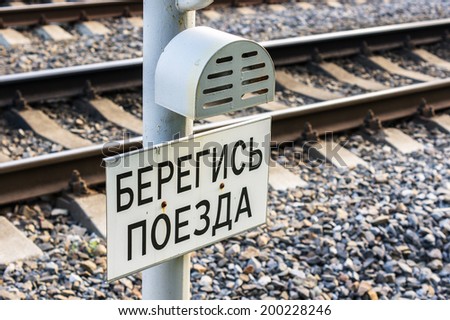 Beware of the train - caution board on a railroad track (russian language)