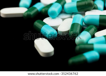 Pile of colorful drugs pills capsules for health care industry in black background