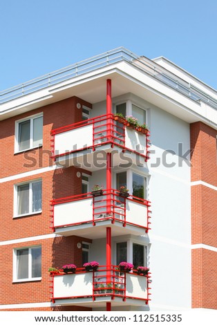 Detail of house with red balcony.
