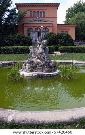 Small fountain with sculptures of boys in garden