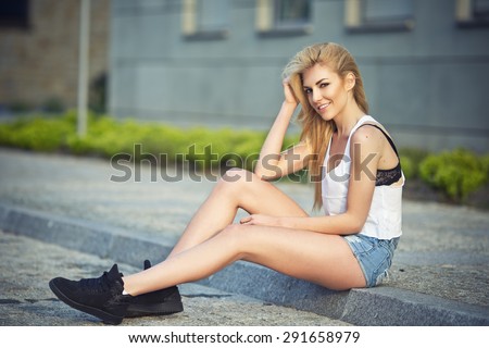 Young skinny sexy woman outdoor posing in summer in city. Fashion swag dressed in jeans sport vintage clothes. Passion style