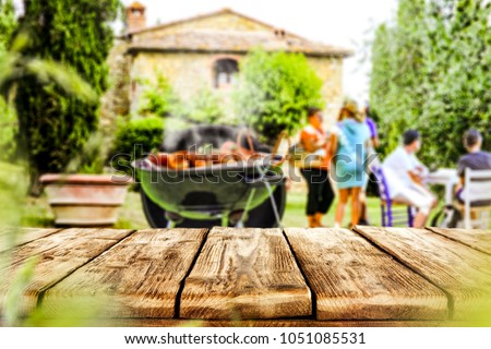 Table background of free space for your your decoration with blurred background with grill party and few people.