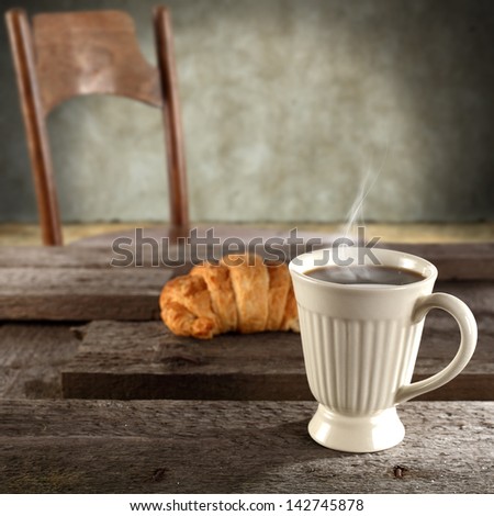 single cup of coffee and retro chair in dark interior