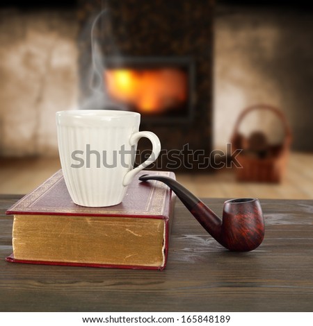 coffee mug on book and brown table with fire background