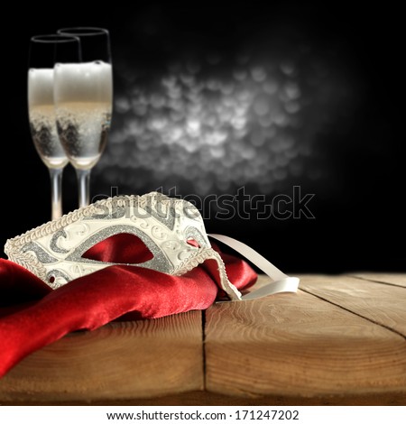 white mask and champagne on red satin