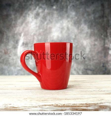 mug and white table and gray wall with free space