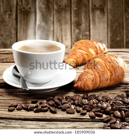 cup of coffee croissants and wall of wood