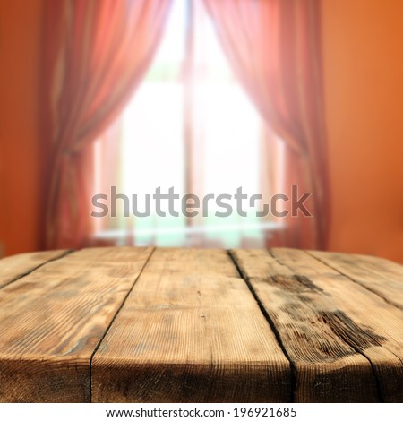 table in room and desk of wood and window space of light and orange color
