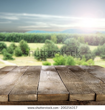 retro old worn table with landscape with sun sky and forest