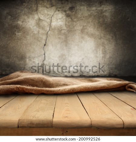 empty table of wood and worn gray wall space