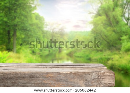 gray worn wooden desk river and green trees with summer