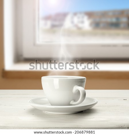 warm coffee in white cup and window space