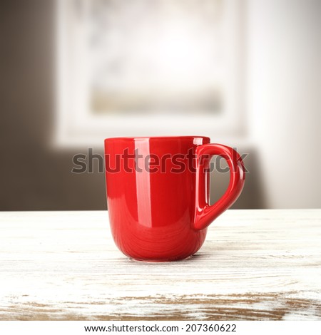 red mug and white table with window