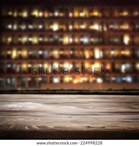 dark desk of wood and city in night