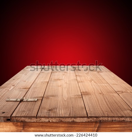 empty wooden top of box and red wall for you text