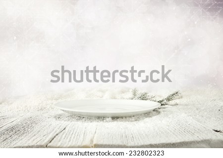 free space of plate and white snow on wooden table top