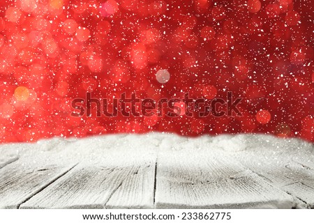 winter wooden board with snow with red space of lights
