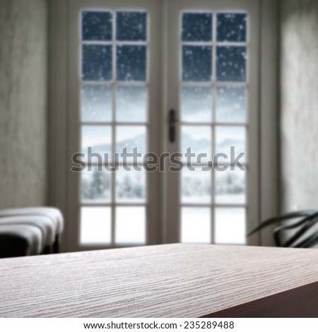 big window in interior of home with winter landscape and dark board
