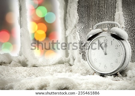 xmas tree and clock on wooden sill with snow