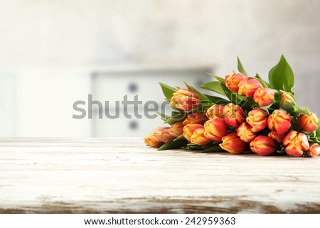 white table top and flowers of tulips and wall