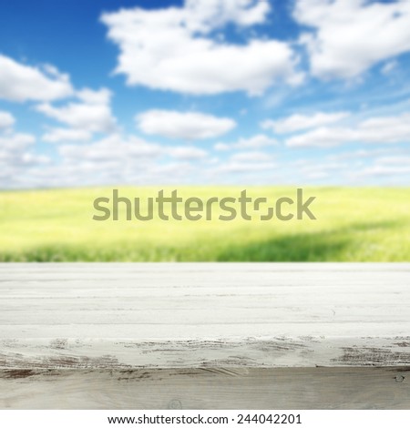 spring background of meadow sky and white table