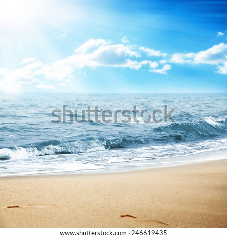 landscape of ocean and sun on sky with sand
