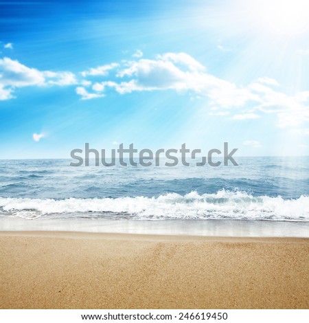 landscape of ocean and sun on sky with wet sand