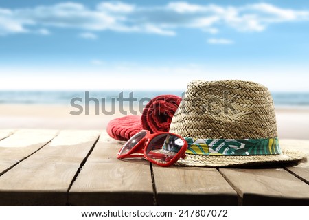 decoration of sun hat and glasses on table with sand