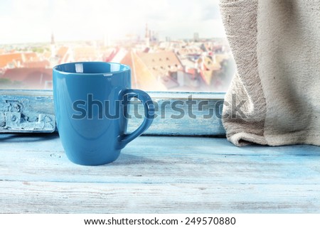 town and blue mug on window  sill
