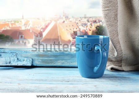 window of blue and mug of blue with city landscape