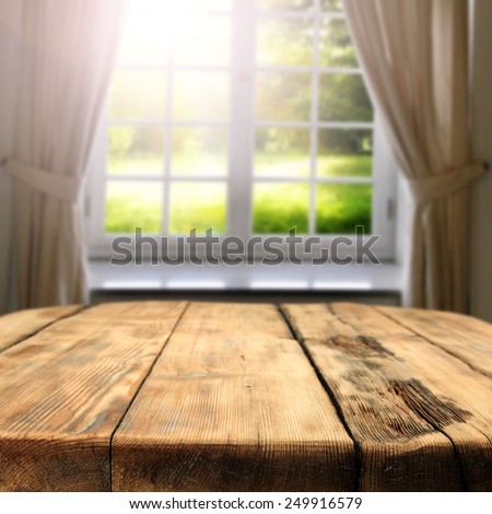 green sunny view of garden in window and big old table place