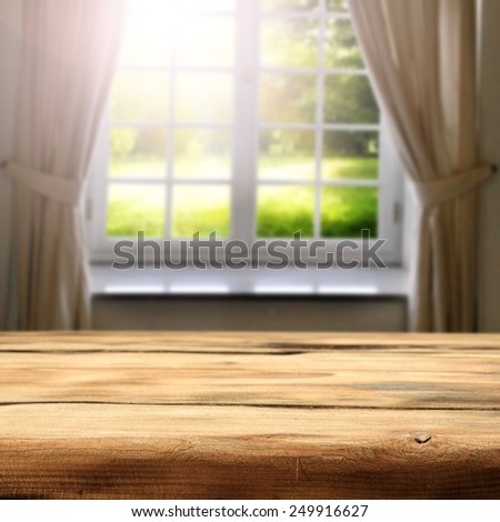 green sunny view of garden in window and desk space of wood