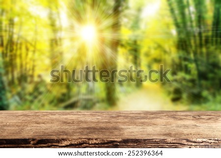 green spring forest background of sun light and brown desk and space for your decoration