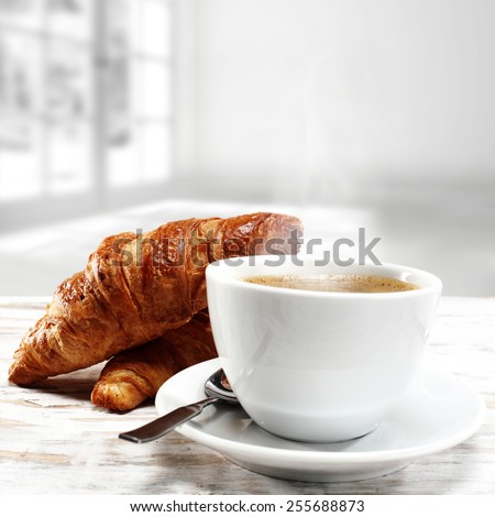 coffee cup of white color and croissants