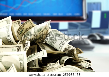 blue blurred background of computer and money of dollars