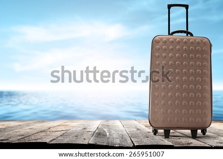 brown suitcase wooden pier and sea of blue with sky of blue color