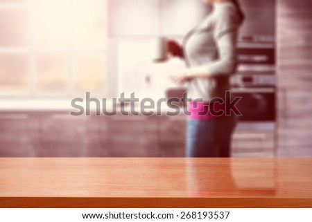 woman with white cup in kitchen place and red desk top and sun light