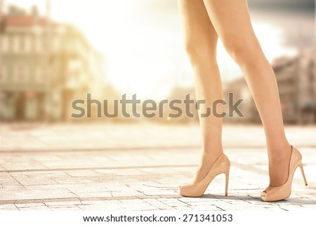 shoes and woman legs in city and sunset