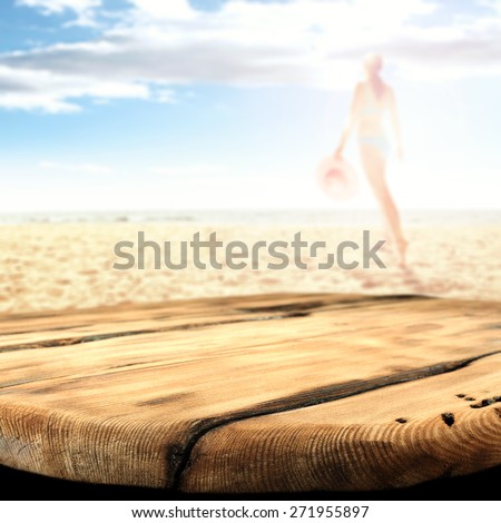 woman in bikini on hot summer sand of beach and worn old table and summer day