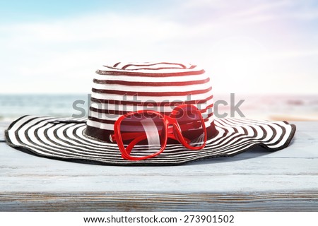 red glasses and hat on desk of blue color