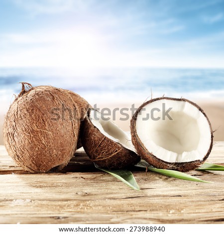 desk of wood in brown color coconuts and sea with summer sky