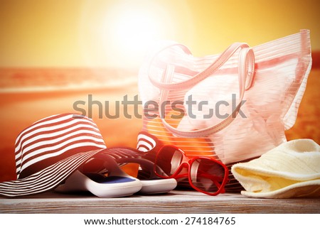 summer sunset and glasses of red color bag and hat in white and blue color