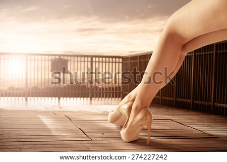 woman legs on wooden pier and sunset time of summer