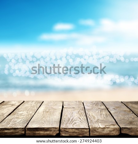 blurred background of sea coast and old table of wood