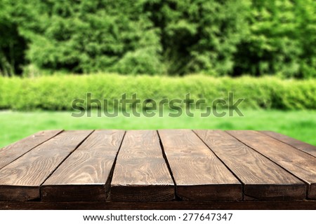 brown old table and green garden space with green grass