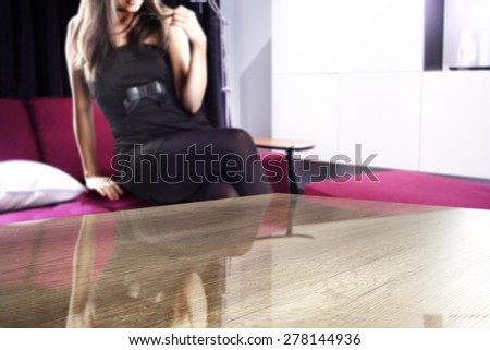 woman on red sofa in home and brown desk top