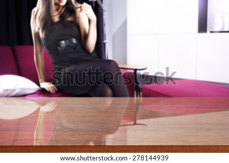 woman in black on red sofa and brown desk