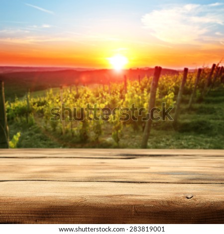vineyard at sunset in the Chianti region in Italy and wooden desk of free space for you and garden