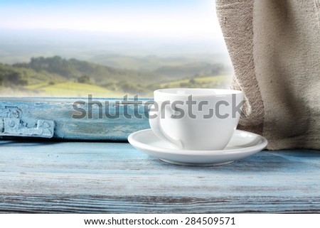 white mug of coffee and blue window sill