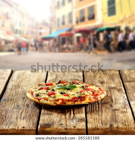 romantic alley in Italy and pizza on table